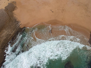 Fototapeta na wymiar Aerial view of sandy beach with waves and clear ocean water. Drone photo