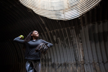Girl in tunnel throwing softball