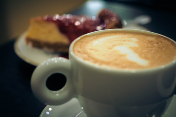 Cup of coffee with milk with delicious cake