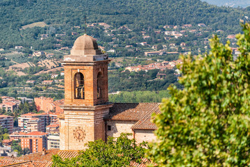 Fototapeta na wymiar Perugia, Umbria, Italy historic old medieval Etruscan church bell tower cross and rooftops of town village in summer