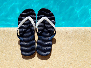 Summer background with slippers for the pool fuchsia colors near the pool