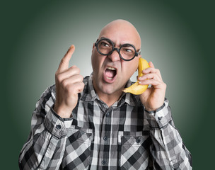 Hombre enfadado hablando a través de un plátano