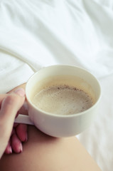 Sexy women relaxing in bad with cup of hot coffee