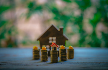 A small house on a pile of coins is used as an asset, financial concept for mortgage, financial investment fund and home loan, interest rate.