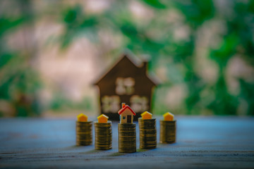 A small house on a pile of coins is used as an asset, financial concept for mortgage, financial investment fund and home loan, interest rate.