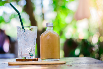 coffee glass bottles and glass have only ice on wood desk