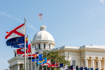 Montgomery, USA State capitol building in Alabama during sunny day with old historic architecture of government and many row of flags by dome - obrazy, fototapety, plakaty