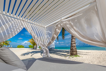 Fototapeta na wymiar White beach canopies. Luxury beach tents at a resort. Wonderful view of beach scenery, luxury vacation and travel background concept