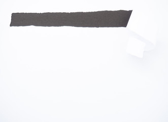 Torn white paper isolated on black