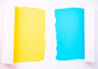 Torn pastel pink paper isolated on yellow and blue