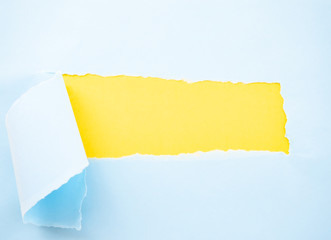 Torn pastel pastel blue paper isolated on yellow