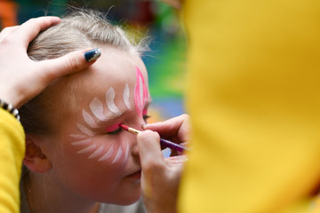 Animator draws a girl drawing on the face at a party