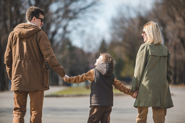 young happy family father mother and son. view from behind