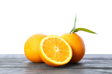 Ripe oranges with leaves on wooden table isolated on white background. Citrus food