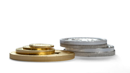 Gold and silver coins in close up isolated on white background.