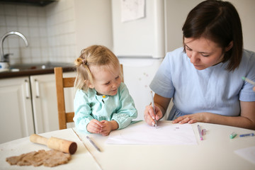 mother and daughter together at table in kitchen