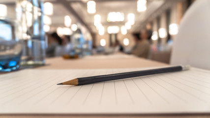 Business agenda briefing shorthand note in seminar workshop or convention hall meeting room with pencil on notepad for taking note on desk and blur people background - obrazy, fototapety, plakaty