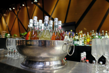 Bottle of champagne in bucket of ice. Bar counter.