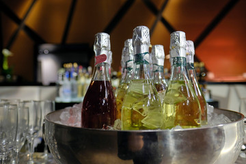 Bottle of champagne in bucket of ice. Bar counter.