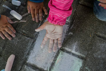 Kinderhände beim spielen mit Kreide