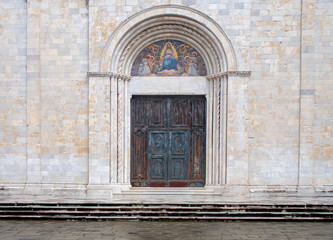 Fototapeta na wymiar Main door of Sarzana cathedral, dedicated to the Assumption of the Virgin Mary. Beautiful artwork. In Liguria, Italy.