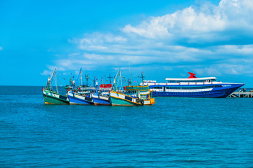 Naklejka premium Fishing boat parking near fisherman floating wooden house in the gulf.