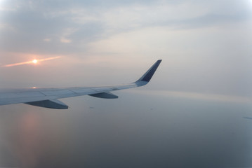 Fototapeta premium airplane wings during sunset in a clear pinky sky.