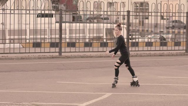 Woman skating by the sea. The girl goes rollerblading and does tricks and stretching on the rollers. Caucasian woman outdoor at sunrise