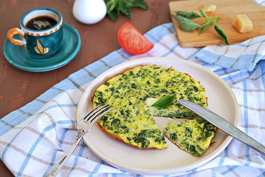 Breakfast, omelet with nettles on a white clay plate. Healthy food. Food from wild herbs.