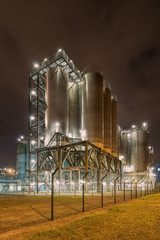 Night scene with silos on Illuminated petrochemical production plant, Antwerp, Belgium.