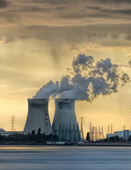 Riverbank with nuclear power plant Doel during a sunset with dramatic cluds, Port of Antwerp,...