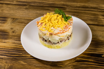 Traditional russian salad Mimosa on wooden table