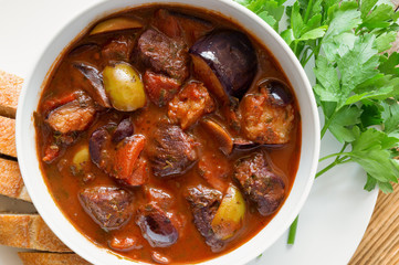 braised veal stew with tomatoes, olives, eggplant, spices, herbs, and red wine