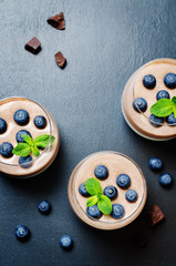 Greek yogurt vanilla chocolate panna cotta with mint leaves and fresh blueberries