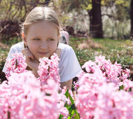 Beautiful slim little girl teenager walks in the flowered garden. Children's portrait. Spring. The game is in the open air. Summer educational camp.