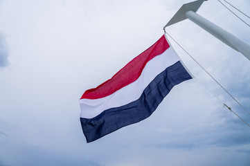 Waving flag of the Netherlands fixed to yacht mast