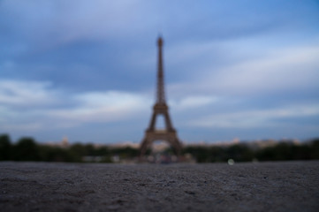 Eifel Tower in blur with foreground stone surface in focus taken from Trocadero in France Paris 