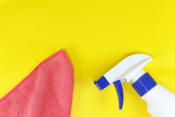 yellow background on the theme of cleaning with a spray and a rag with copyspace