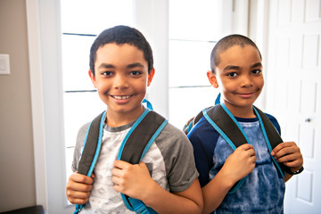 A child boy coming home passing through the door after school