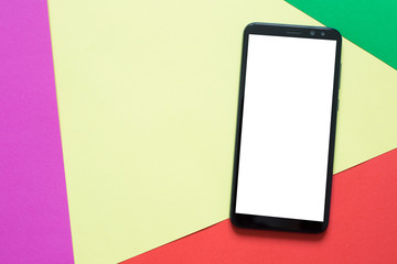 Top view mockup smartphone with a white screen on a multi colored pastel background. 