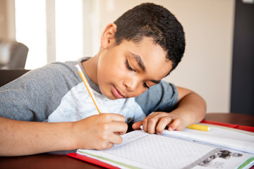 A male black child doing homework at home