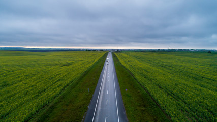 Fototapeta na wymiar Highway between two green fields