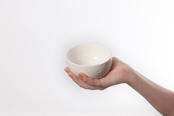 Porcelain dish bowl in hand isolated on white background