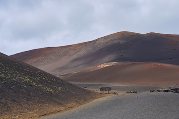 landscape view on Timanfaya national park in Lanzarote on a cloudy day, the sign means in English no entry to the national park