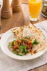 Baked vegetables with parsley and lavash bread on wooden table