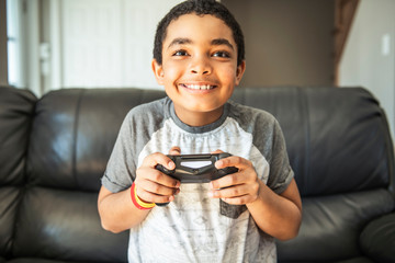 Young boy playing video game, at home.