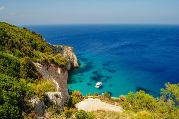 Zakynthos Island coast line, with crystal clear waters and a isolated boat in summer.