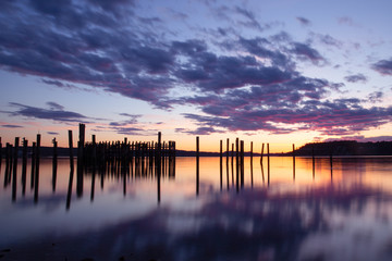Obraz premium dramatic purple cloudy sunset with horizon over water and reflections