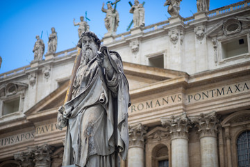 Fototapeta na wymiar Statue of Saint Peter and Saint Peter's Basilica at background in St. Peter's Square, Vatican City, Rome, Italy
