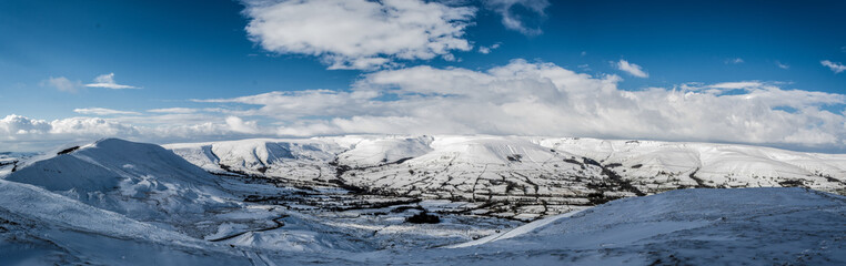 A panoramic view of the peak district in winter with snow on the mountains from a high postion.